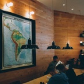 A photograph of our maps room, a few college students looking at a South America map from their desk.
